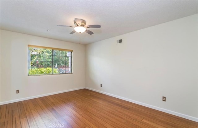 unfurnished room featuring hardwood / wood-style flooring, ceiling fan, and a textured ceiling