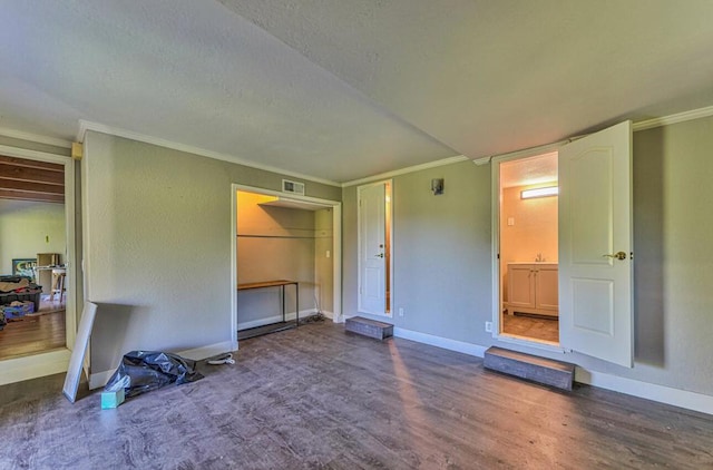 unfurnished living room with ornamental molding and hardwood / wood-style floors