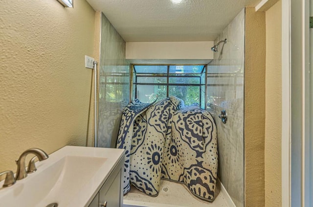 bathroom featuring vanity, curtained shower, and a textured ceiling