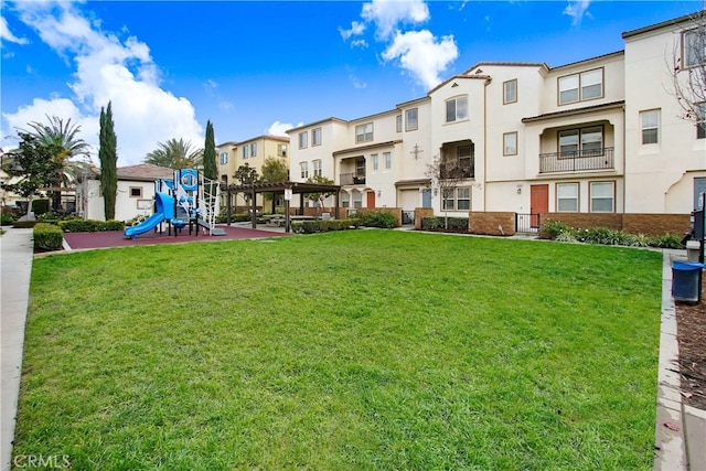 view of home's community featuring a playground and a yard