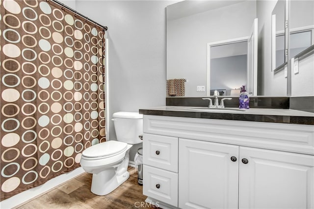 bathroom with hardwood / wood-style floors, toilet, vanity, and a shower with shower curtain