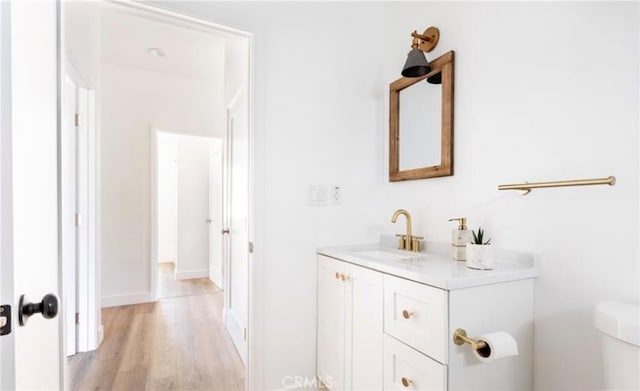 bathroom with vanity, toilet, and wood finished floors