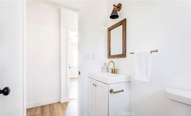 bathroom with vanity, wood-type flooring, and toilet