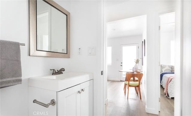 bathroom with ensuite bathroom, wood finished floors, and vanity