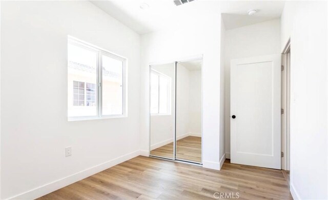 unfurnished bedroom featuring a closet and light hardwood / wood-style floors