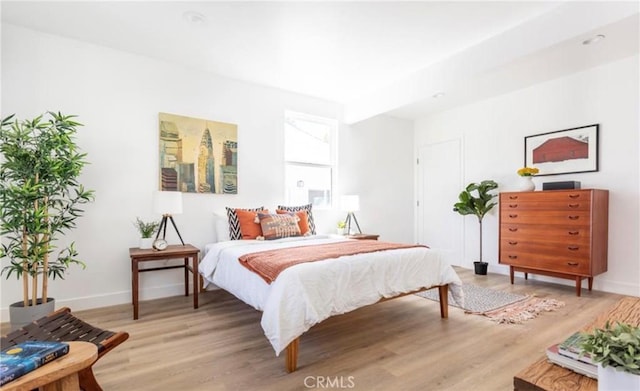 bedroom with baseboards and wood finished floors