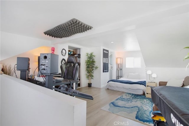 bedroom featuring lofted ceiling and light wood-style flooring