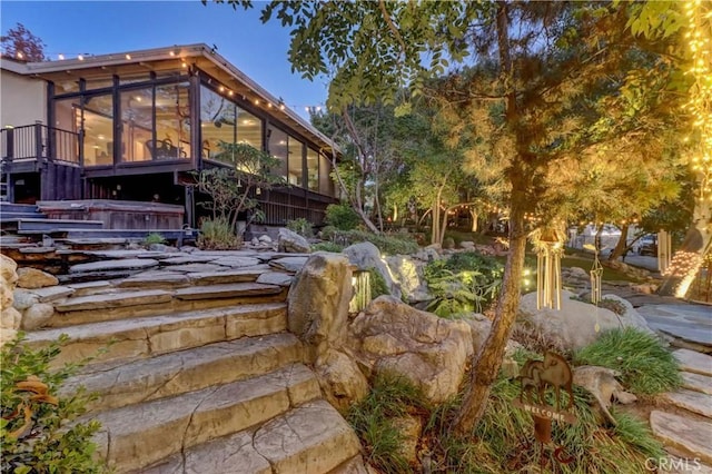 view of yard with a hot tub and a sunroom