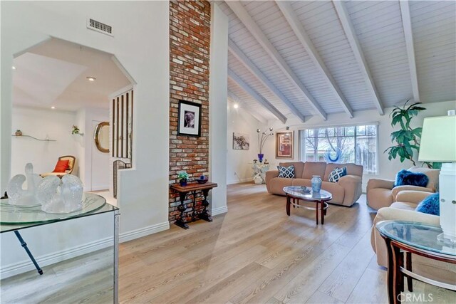 living room with high vaulted ceiling, light hardwood / wood-style floors, and beamed ceiling