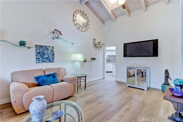 living room featuring beamed ceiling, wooden ceiling, light wood-type flooring, and a skylight