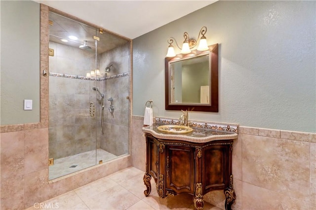 bathroom featuring tiled shower, tile patterned floors, tile walls, and vanity