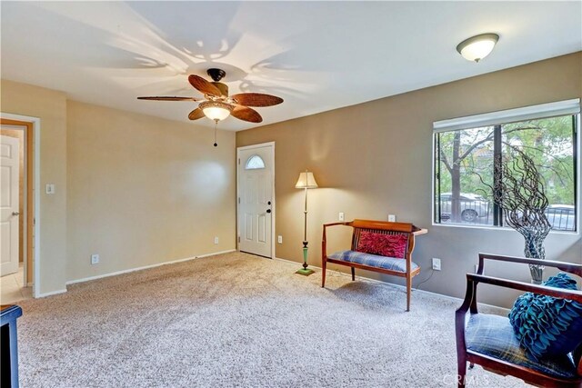 living area with carpet floors and ceiling fan