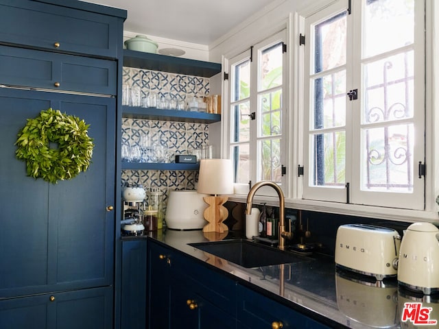 bar featuring tasteful backsplash, sink, and blue cabinetry