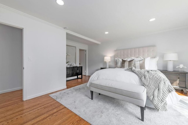 bedroom featuring crown molding and light hardwood / wood-style flooring