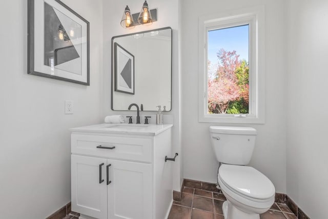 bathroom with toilet, vanity, and tile flooring