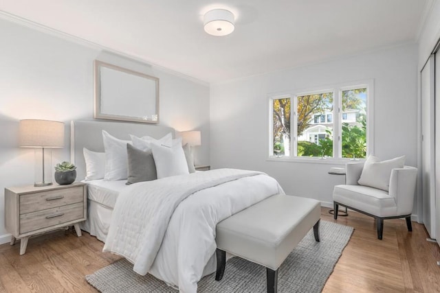 bedroom with crown molding and light hardwood / wood-style floors