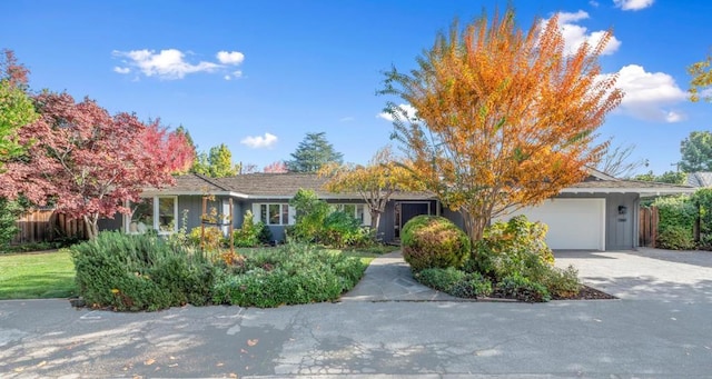 view of property hidden behind natural elements featuring a garage