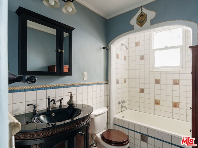 full bathroom featuring toilet, tiled shower / bath, and vanity