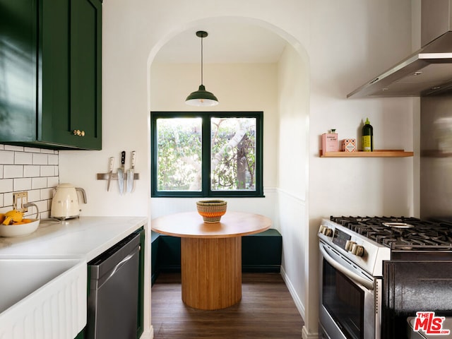 kitchen featuring pendant lighting, green cabinetry, stainless steel appliances, backsplash, and dark hardwood / wood-style flooring