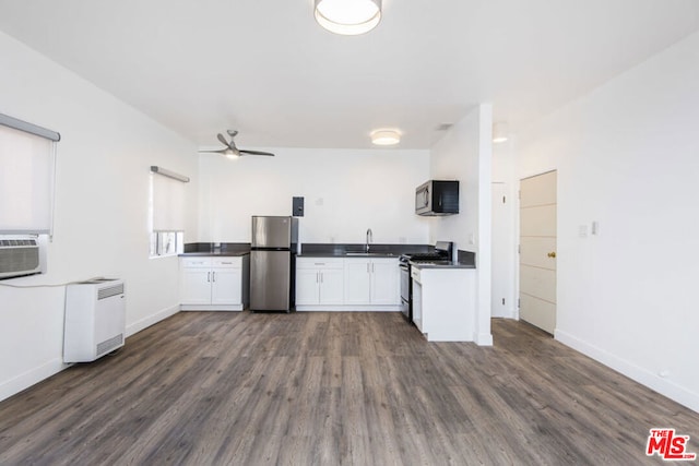 kitchen featuring appliances with stainless steel finishes, white cabinetry, ceiling fan, dark hardwood / wood-style floors, and sink