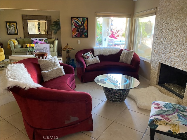 living room with a high end fireplace and tile patterned flooring