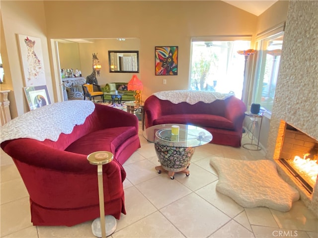 living room with lofted ceiling, tile patterned flooring, and a high end fireplace