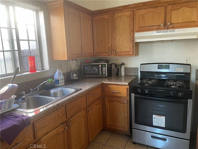 kitchen with appliances with stainless steel finishes, light tile patterned floors, and sink