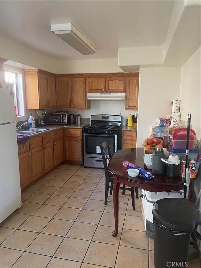 kitchen with sink, light tile patterned floors, and appliances with stainless steel finishes