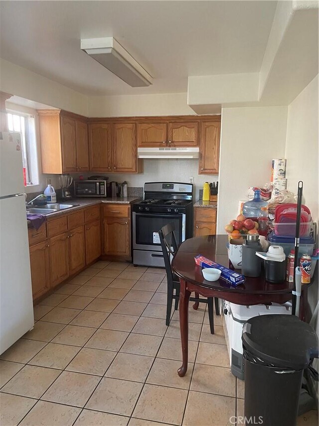 kitchen with appliances with stainless steel finishes, light tile patterned floors, and sink