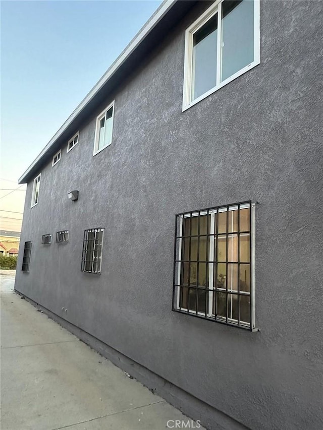 property exterior at dusk featuring a patio