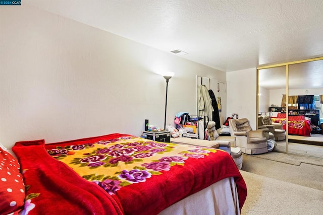 bedroom featuring a closet, carpet, and a textured ceiling