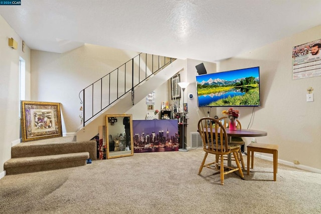 carpeted dining space with a textured ceiling