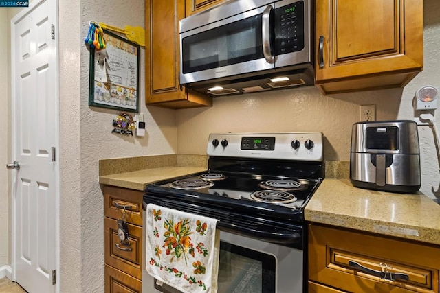 kitchen with light stone countertops and stainless steel appliances