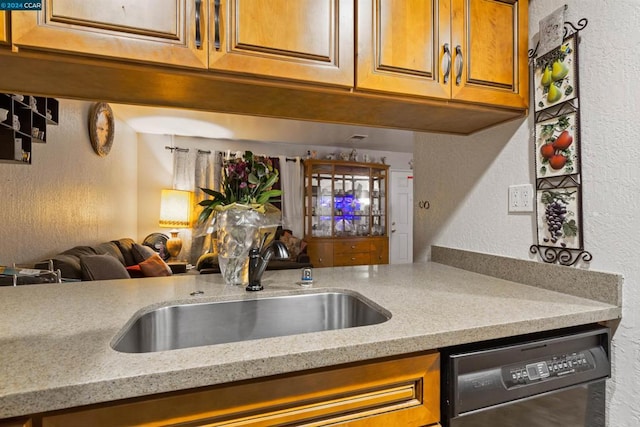 kitchen with light stone counters, sink, and dishwasher