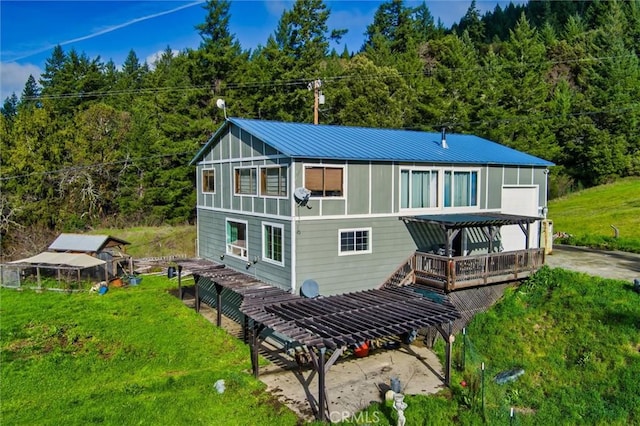 rear view of property featuring a deck and a pergola