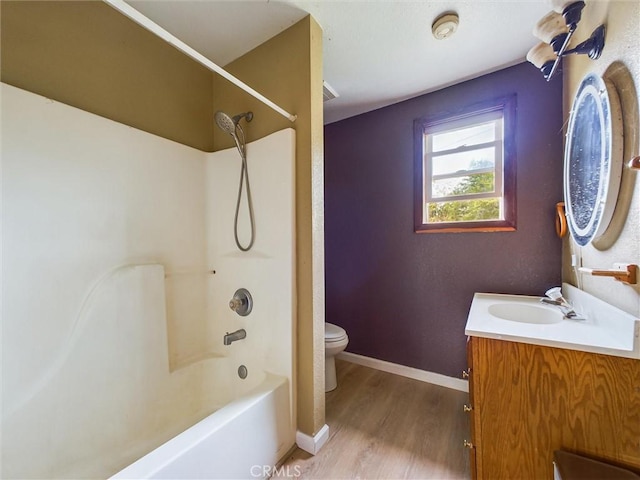 full bathroom with washtub / shower combination, hardwood / wood-style floors, vanity, and toilet