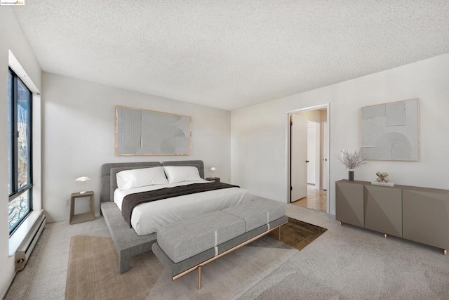 carpeted bedroom featuring a textured ceiling and a baseboard heating unit