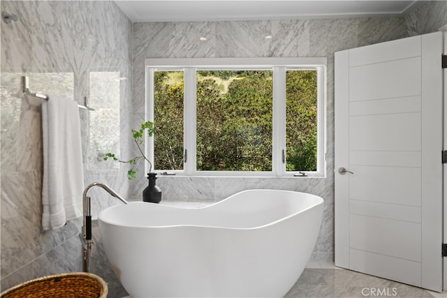 bathroom featuring tile walls, a bathing tub, and a wealth of natural light