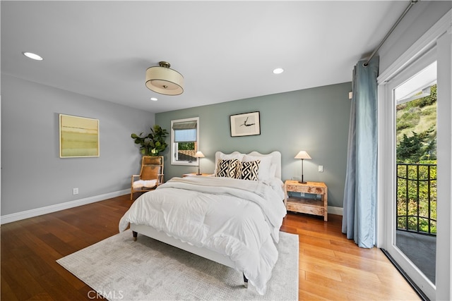 bedroom featuring access to exterior and hardwood / wood-style floors