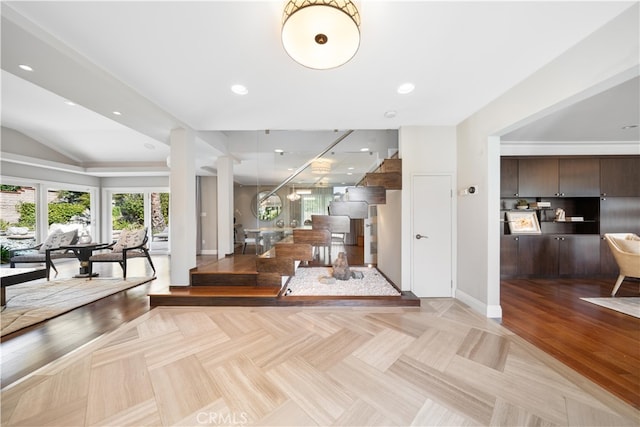 interior space with light parquet floors, dark brown cabinetry, and vaulted ceiling