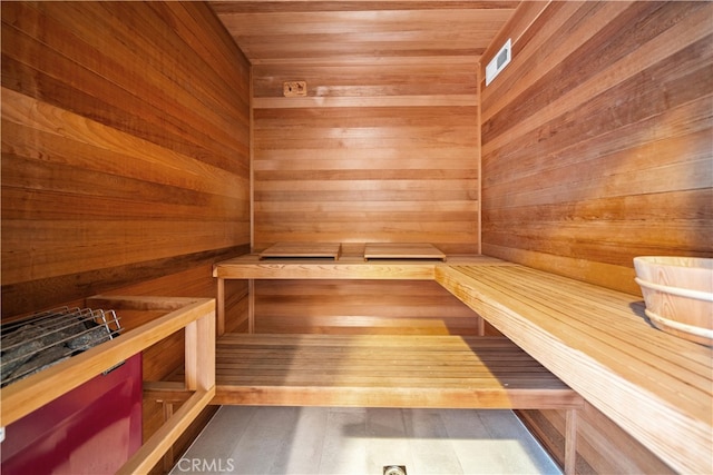 view of sauna / steam room with wooden ceiling, wooden walls, and hardwood / wood-style floors