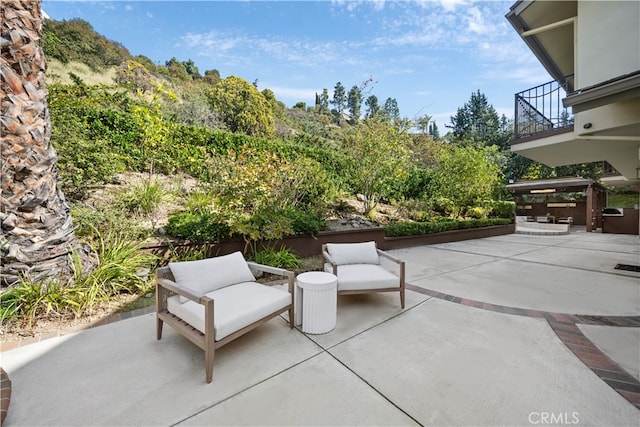 view of patio featuring a balcony and exterior kitchen