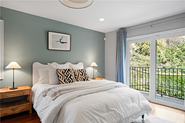 bedroom with access to outside and hardwood / wood-style floors