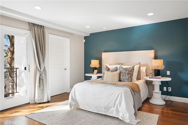 bedroom featuring access to outside, hardwood / wood-style floors, and multiple windows