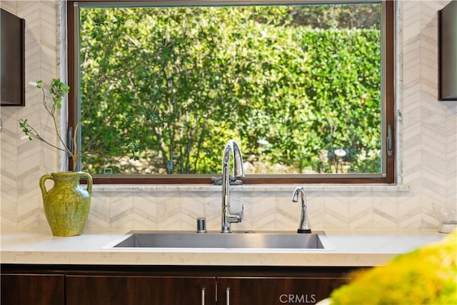 kitchen featuring tasteful backsplash, dark brown cabinetry, and sink