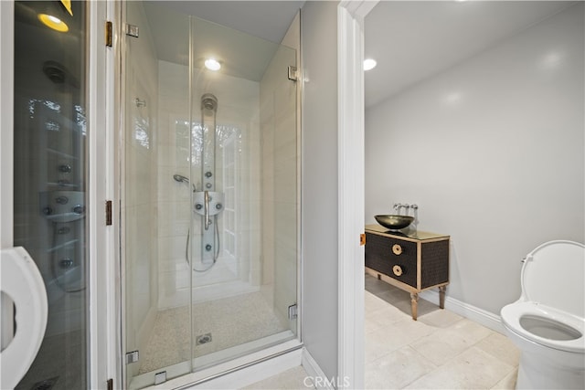 bathroom featuring tile patterned flooring, a shower with door, and toilet