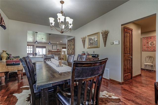 dining area with an inviting chandelier and dark hardwood / wood-style floors