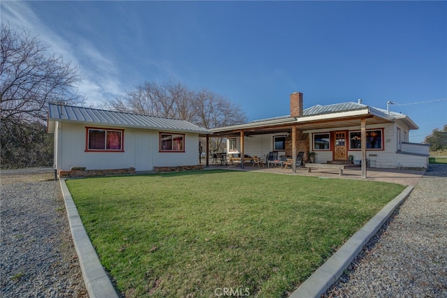 rear view of house featuring a lawn