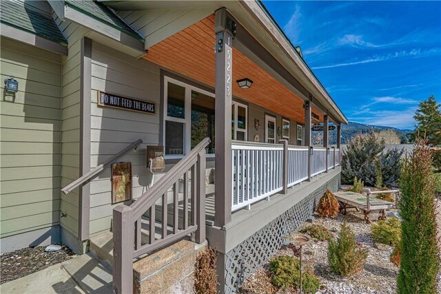 view of side of home featuring covered porch