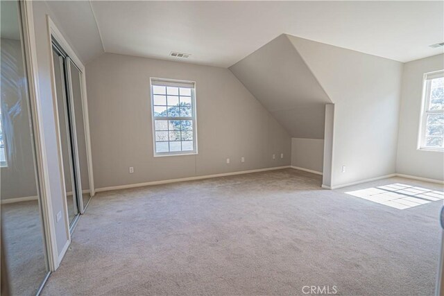 additional living space featuring a healthy amount of sunlight and light colored carpet